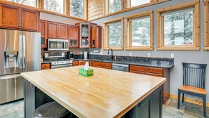 A modern kitchen with wooden cabinets, stainless steel appliances, and large windows. - Lakefront Gem w/ Dock & Views in Lac Du Flambeau (Lac Du Flambeau)