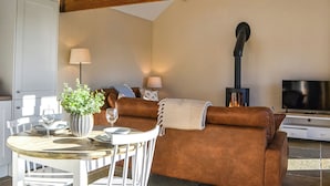 Una sala acogedora con chimenea, una mesa de comedor con sillas y un sofá.