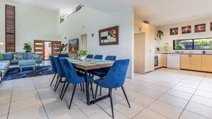 Un espacio habitable moderno con comedor, cocina y un gran ventanal.