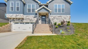 A two-story house with a stone facade, a front entrance with steps, and a garage. - Cherokee Lake Retreat w/ Views in Morristown! (Morristown)