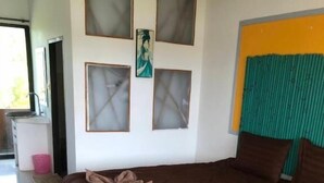 A bedroom with a large bed, a window with blinds, a small table with a pink container, and a painting on the wall. - Petpumok Wangnamkhiao Hotel (Wang Nam Khiao)