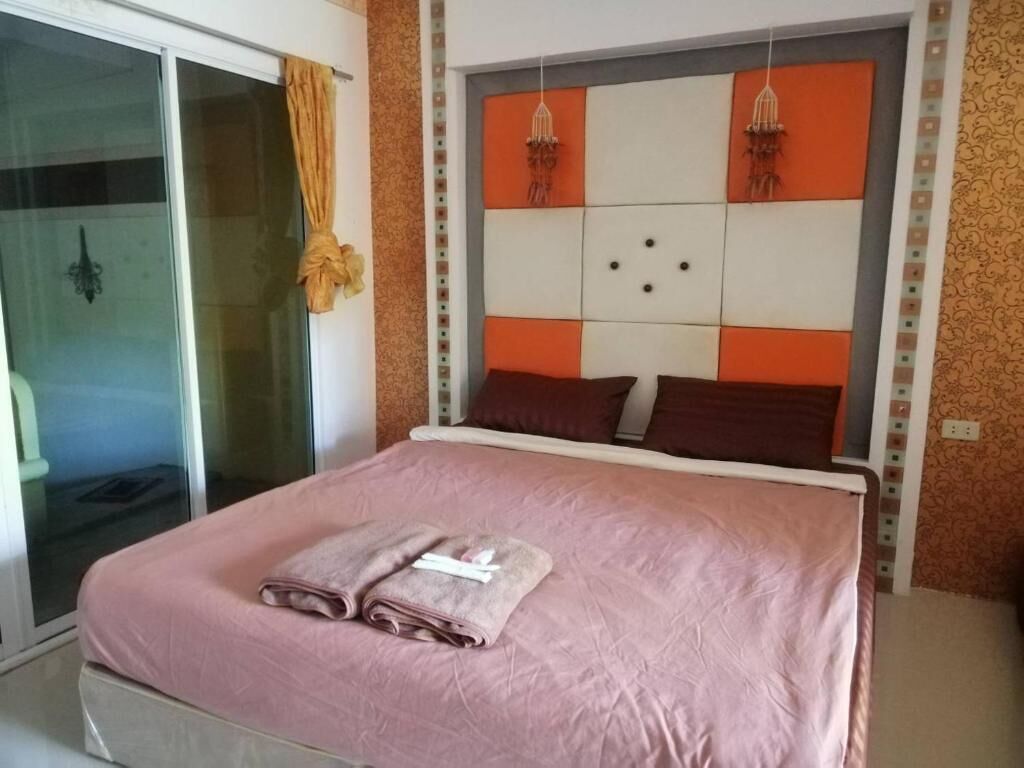 Un dormitorio con una cama, una puerta de cristal y un muro estampado.