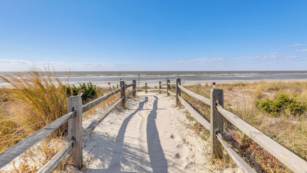 A wooden pathway leading to the beach with sand and grass on either side. - Beachfront Home ~ 7 Mi to Cape May! (Villas)