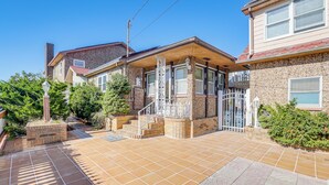 A residential house with a tiled patio, a gated entrance, and a small front yard with a lamp post and potted plants. - Beachfront Home ~ 7 Mi to Cape May! (Villas)