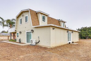 A two-story house with a sloped roof, a front porch, and a small attached garage. - Patio & Workspace: Peaceful Riverside Retreat! (Riverside)