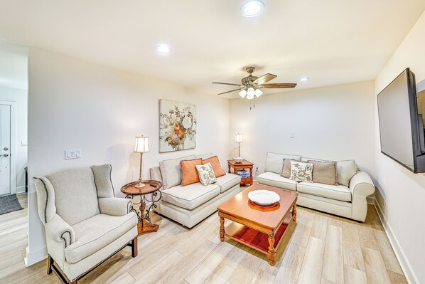 A living room with a sofa set, a coffee table, a side table, and a ceiling fan. - Patio & Workspace: Peaceful Riverside Retreat! (Riverside)