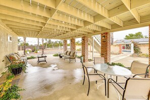 A covered patio area with outdoor seating, including a sofa and chairs, and a table. - Patio & Workspace: Peaceful Riverside Retreat! (Riverside)