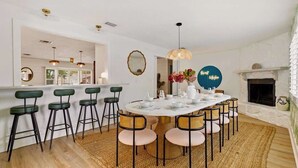 A dining area with a round table, bar stools, and a fireplace. - 4 Br Oasis~Pool~Tiki Hut~Hot Tub~Ping Pong~Arcade (Seminole)