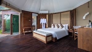 A spacious bedroom with a large bed, wooden flooring, and a view of a green garden. - The Wapa Lux Tent (Sidemen)