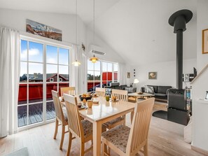 Enjoy a spacious living area with a dining table, sofa, and fireplace, offering a view of the outside.