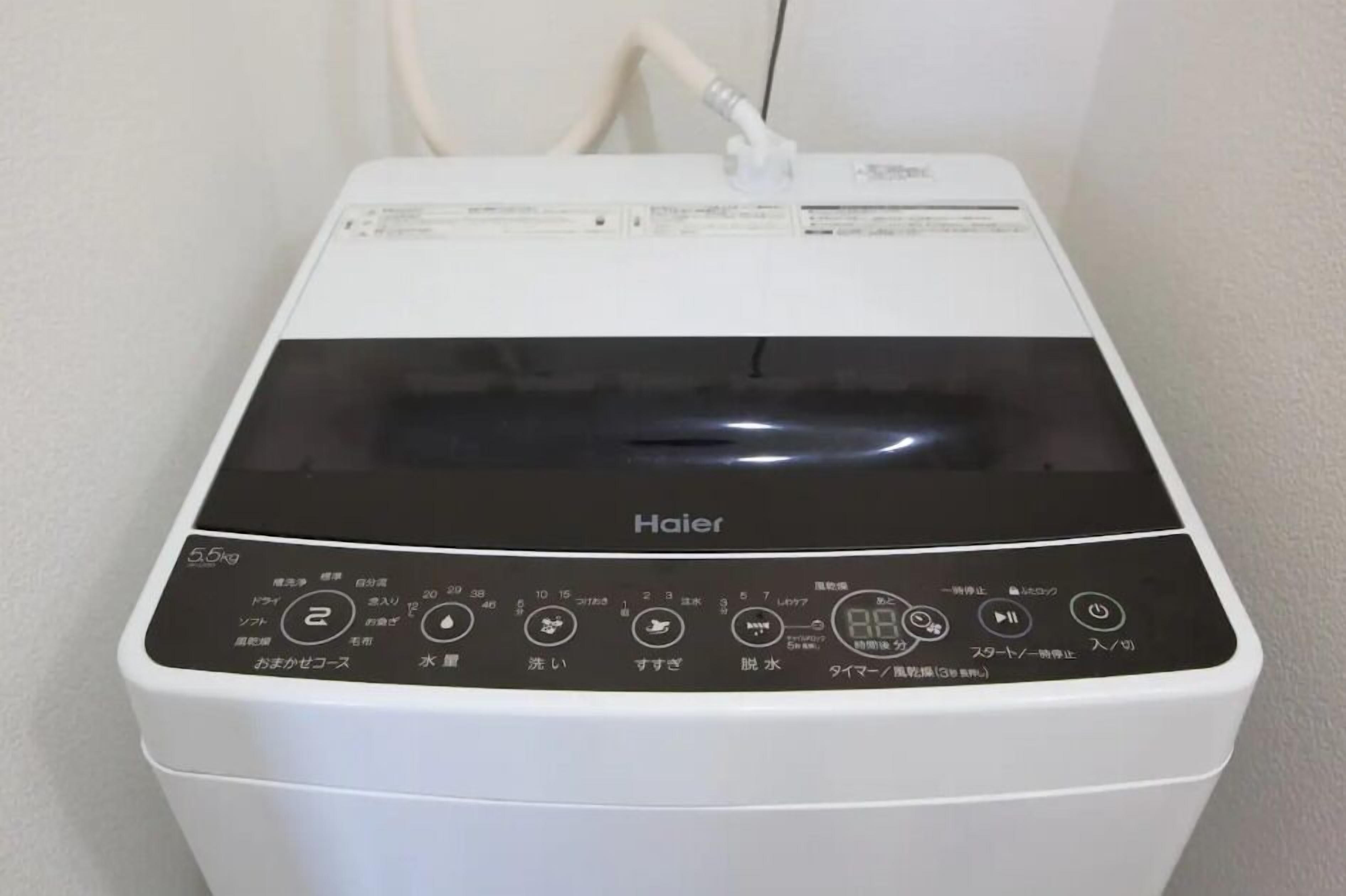 Una lavadora Haier blanca y negra con un panel de control que muestra varias configuraciones y botones.