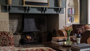 Un salon chaleureux avec une cheminée, une bibliothèque et un canapé en cuir.