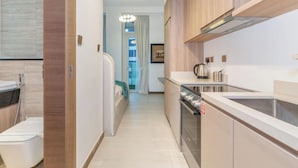 A modern kitchen with wooden cabinets, a built-in oven, and a countertop with a kettle.