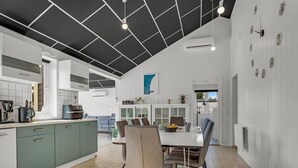 A modern kitchen with a dining area, featuring a central island, grey cabinets, and a black ceiling. - "Amdi" - 1.3km from the sea by Interhome (Væggerløse)