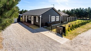A modern two-story house with a dark exterior, a covered porch, and a gravel driveway. - "Amdi" - 1.3km from the sea by Interhome (Væggerløse)