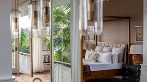 A bedroom with a bed, bedside tables, and a view of greenery outside.