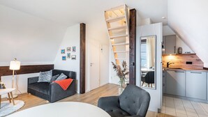 A modern loft apartment with a loft bed, a dining area, a kitchen, and a living room. - Apartment 'Inselliebe' with Balcony and Wi-Fi (Pellworm)