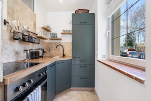 Uma cozinha moderna com forno embutido, pia e janela com vista para o exterior.