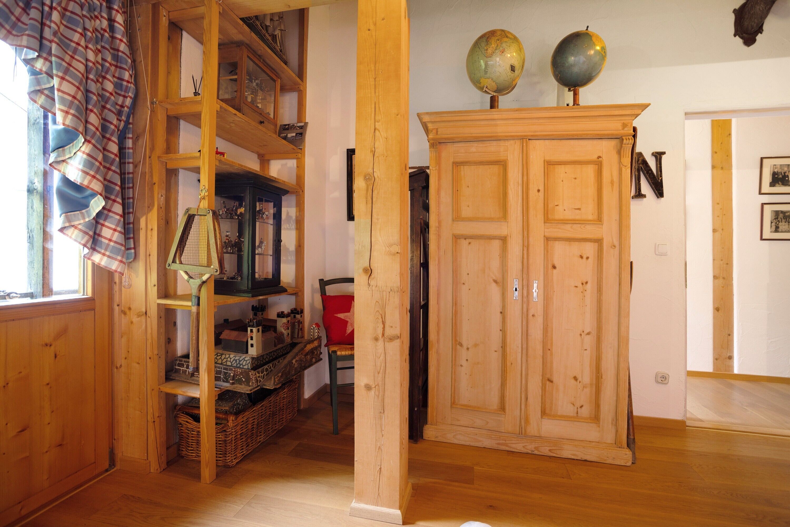 Un intérieur en bois comprenant un meuble, des étagères et un globe terrestre.