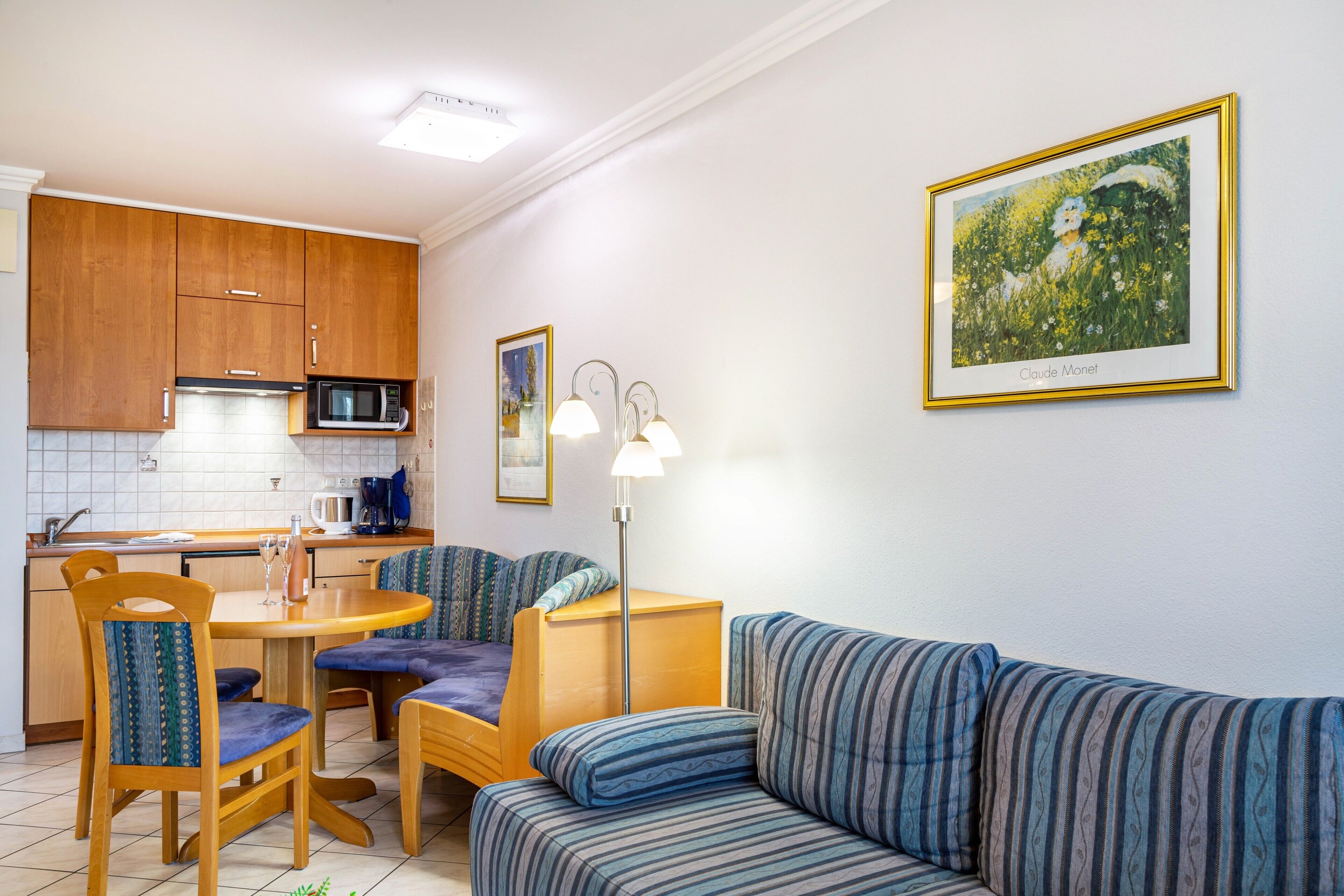 A compact living space with a kitchenette, dining area, and a sofa.