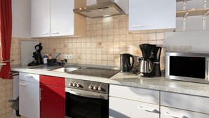 Une cuisine équipée d’une cuisinière, d’un four, d’un four à micro-ondes et d’une machine à café.