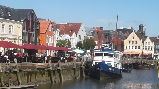 Une zone riveraine avec des bâtiments, un quai et des bateaux.
