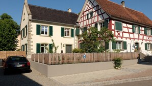 A traditional half-timbered house with a paved driveway and a parked car. - Holiday Home 'Schlößleweg 2a' with Private Terrace, Private Garden and Wi-Fi (Bodman-Ludwigshafen)