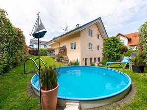 Piscina residencial com uma casa ao fundo.