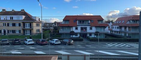 Una calle residencial con coches aparcados y casas.