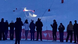 A group of people standing in a snowy area with a banner in the background.