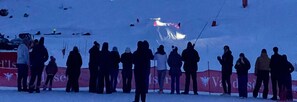 Un grupo de personas en una zona nevada, con un cartel al fondo.