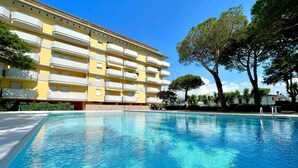 Ein Swimmingpool mit einem gelben Gebäude im Hintergrund.