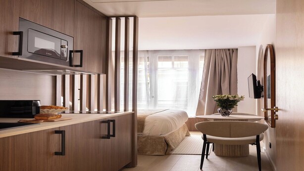 A modern hotel room with a kitchenette, a bed, a bathroom, and a view of the city. - Charming Studio - 2P- Madeleine (Paris)