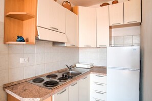 Jääkaappi, liesi, ruokailupöytä