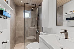 Een douche, handdoeken, zeep, toiletpapier