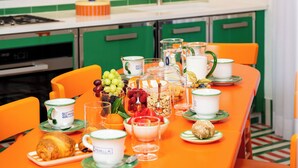 A brightly colored breakfast table with various dishes, cups, and a fruit bowl. - Pepella (Piano di Sorrento)