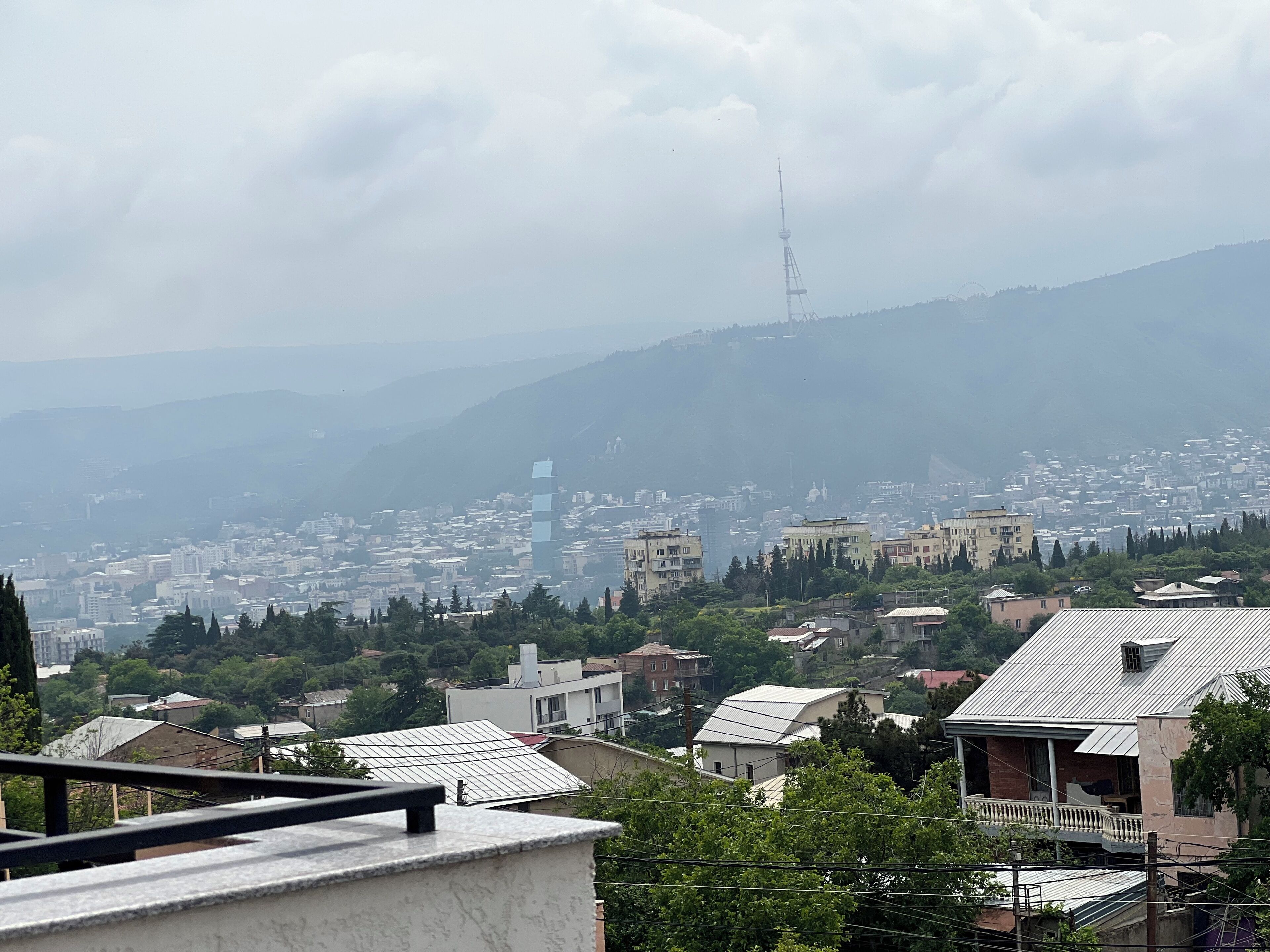 Un paysage urbain avec une tour imposante, des immeubles résidentiels et de la verdure.