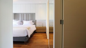 A modern hotel room with a bed, bedside tables, and a large mirror. - w* | Classy 2BR in Miraflores (Miraflores)
