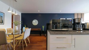 A modern kitchen with a microwave, coffee maker, and a digital clock displaying 10:21. - w* | Classy 2BR in Miraflores (Miraflores)