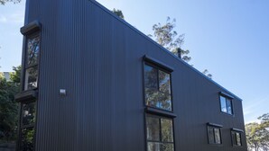 Un bâtiment moderne doté d’une façade incurvée, de grandes fenêtres et d’une structure extérieure en métal.