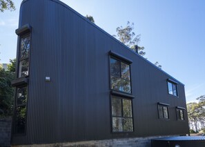 A modern building with a curved facade, large windows, and a metal exterior.