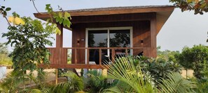 A wooden cabin with a balcony, surrounded by lush greenery. - SN Eco Resort And Water Park (Dhenkanal)