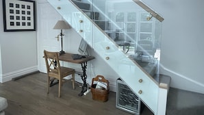 A staircase with glass railings and a wooden desk with a chair and a lamp. - Reed Cottage - Large private garden cottage a perfect base for your Sydney stay (Cremorne)