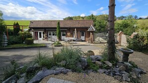 A rustic building with a brick facade, a small porch, and outdoor seating. - Farmhouse in Belgium With Lush Garden Retreat (Hastiere)