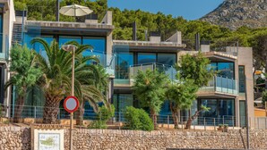 A modern building with a glass facade, a stone wall, and a no-entry sign. - A. Mirador Blue K Cala Sant Vicenç (Cala Sant Vicenç)