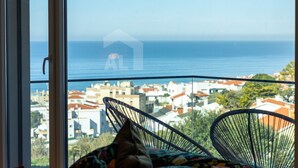 Un balcón con vista al mar y al paisaje urbano.