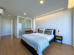 Un dormitorio moderno con una cama grande, un escritorio y una silla.