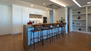 Una cocina moderna con una isla central, taburetes de bar y armarios empotrados.
