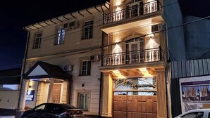 A hotel with a prominent entrance, a balcony on the second floor, and a sign indicating it is a hotel. - BOSTON HOTEL (Tashkent)