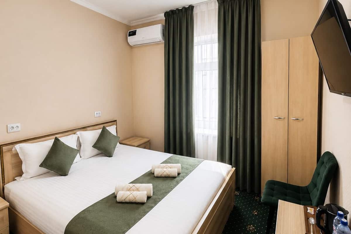 Une chambre d’hôtel équipée d’un lit, d’un bureau, d’une chaise, d’une télévision et d  ’un appareil de climatisation.